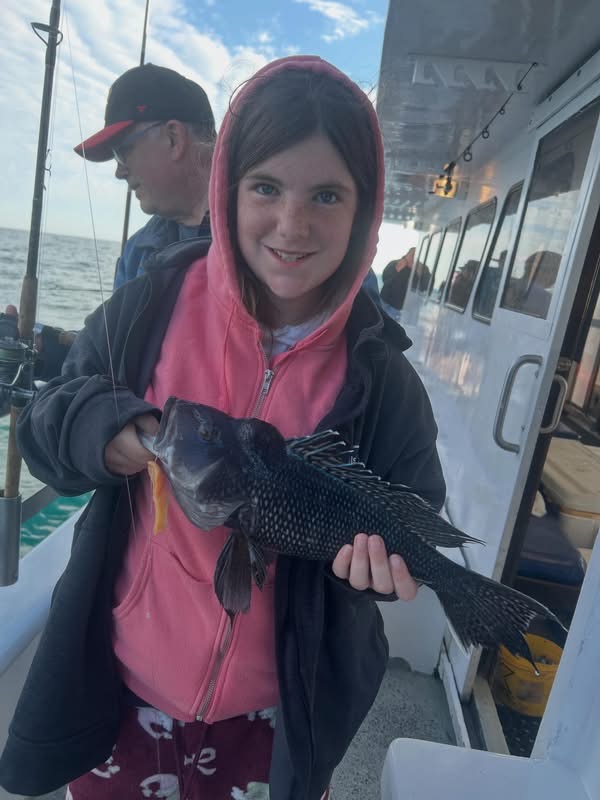 Scout holding sea bass on charter boat off the New Jersey coast